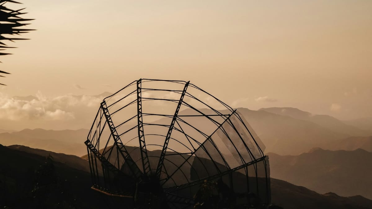 Broken satellite dish on a hill—showing the search for signal in complex systems.