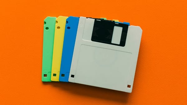 Colorful floppy disks on an orange background, symbolising outdated foundations behind Malaysia’s digital inclusion push.